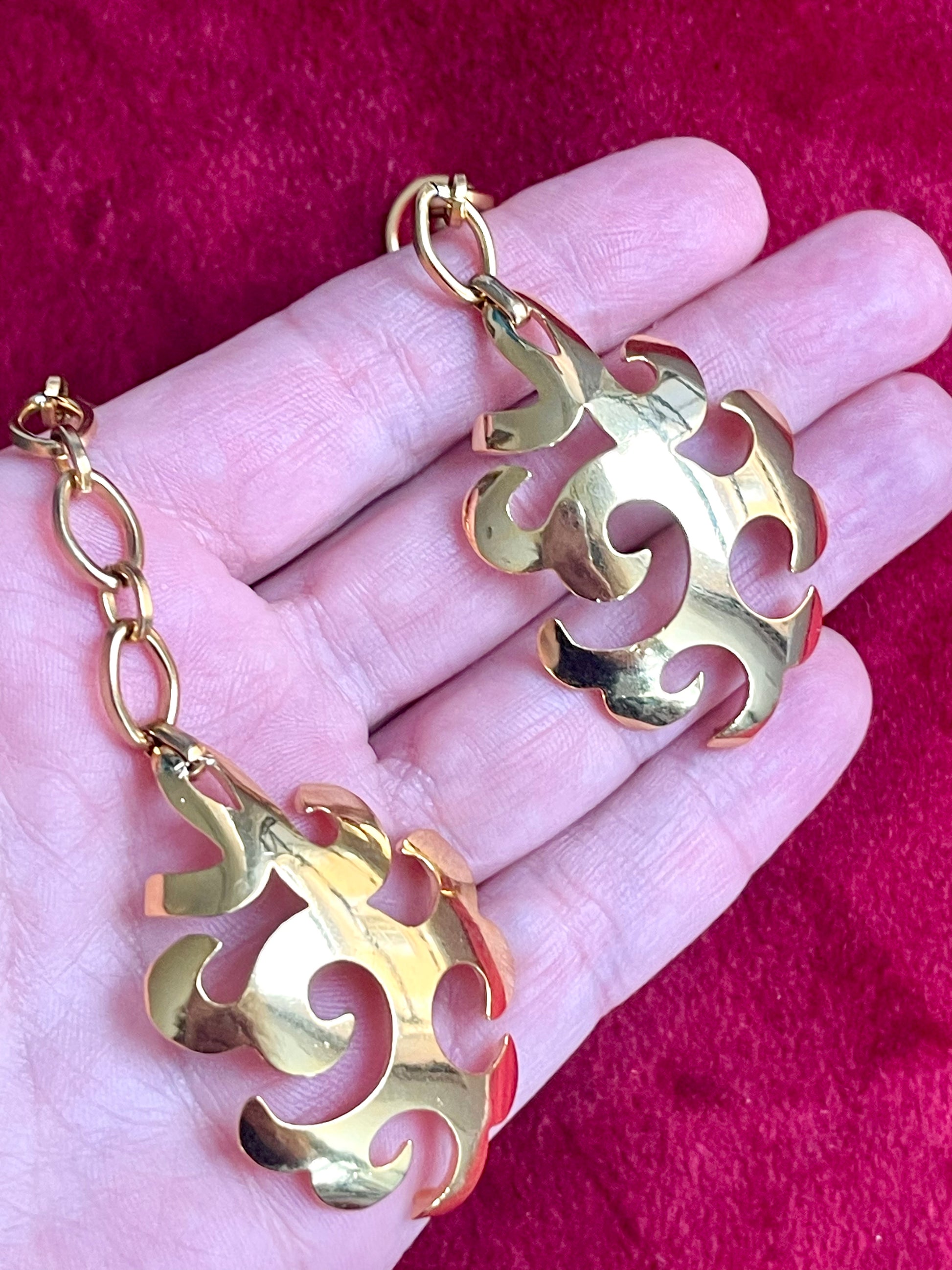 Both earrings shown together front view vintage Yves Saint Laurent jewelry Displayed on hand