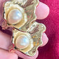 Close up on Authentic vintage Yves Saint Laurent earrings, organic gold-tone flower design with pearl accents