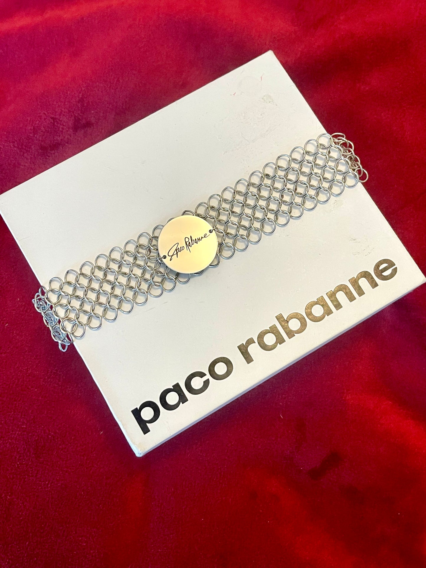 Paco Rabanne silver mesh chain bracelet on a branded card with a red background