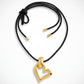 Gold heart-shaped pendant yves saint laurent on a black cord against a white background