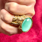 Close-up of the luminous turquoise nacre stone in a vintage gold Yves Saint Laurent arty ring, highlighting its glossy finish and organic setting , worn by model 