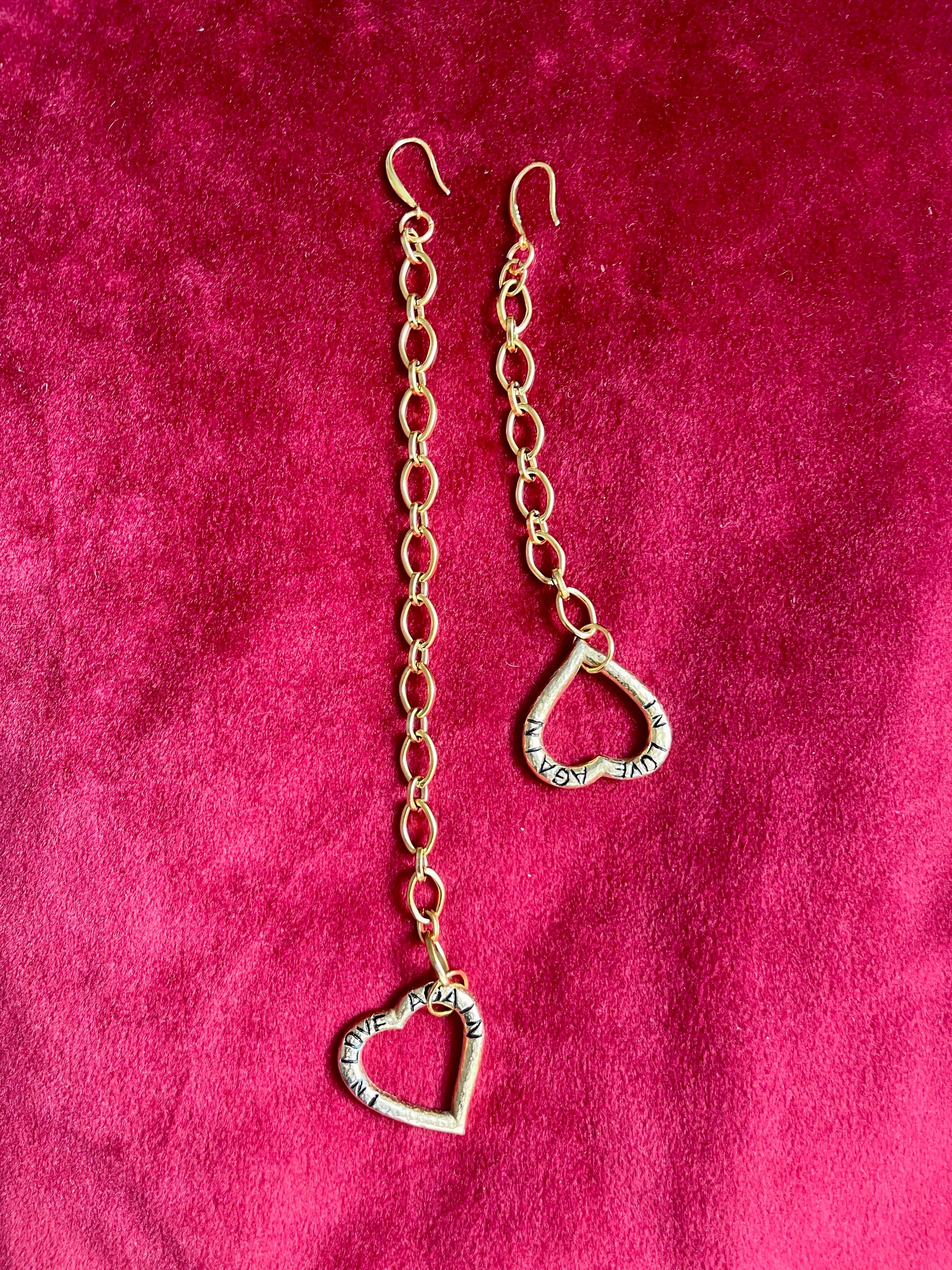 Yves Saint Laurent upcycled heart pendant earrings, front view on pink background