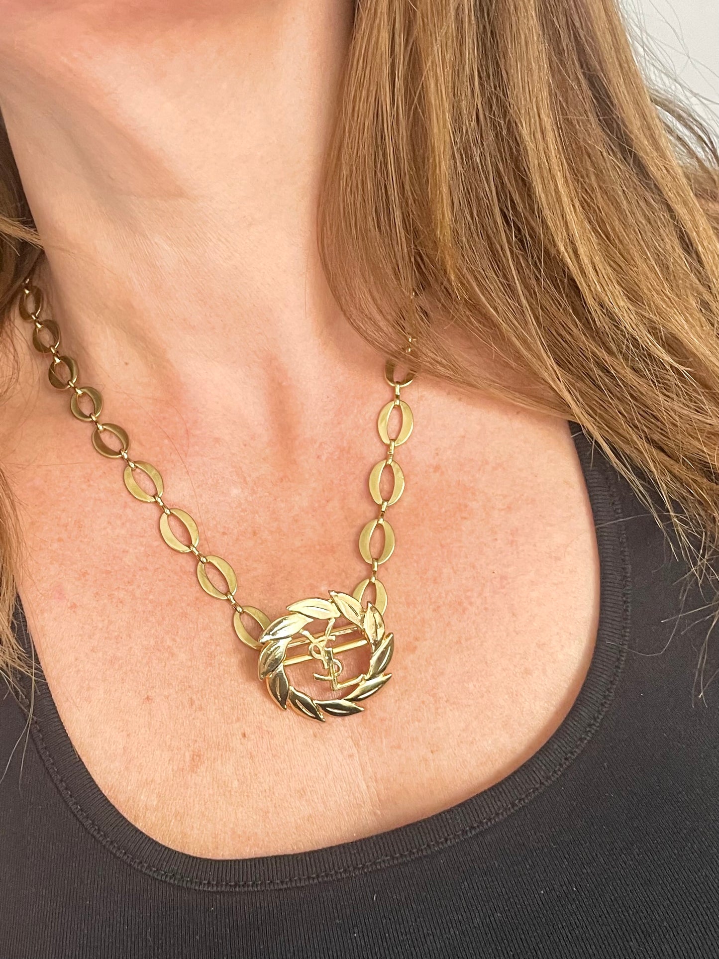 Worn by model a refurbished vintage YSL laurel wreath pendant mounted on a gold-plated stainless steel necklace, with adjustable hoop links and a slightly lighter-toned closure.