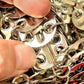 Close up on attachment of brooch Phone holder silver metal Crystal crossbody bag style Paco Rabanne Sparkle 1969 