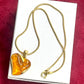 Statement vintage YSL necklace with orange resin pendant on white background