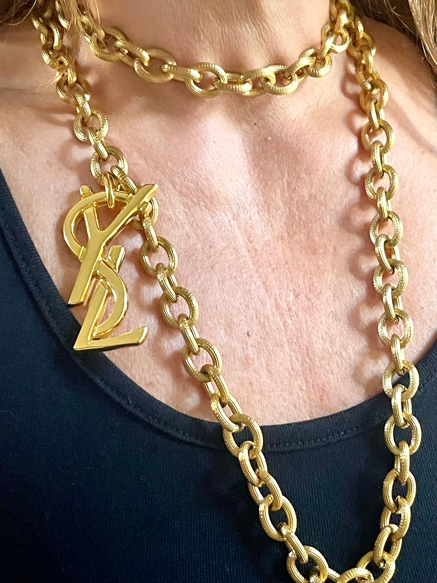 Large Yves Saint Laurent YSL logo pendant from vintage bag charm, styled as long necklace or belt.