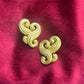 Close-up of vintage Nina Ricci swirly heart earrings in matte gold tone