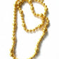 Vintage Yves Saint Laurent gold beaded necklace with textured graduated beads displayed on white background.