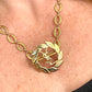 Close-up of a person wearing a refurbished vintage YSL laurel wreath pendant mounted on a gold-plated stainless steel necklace
