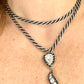 Close up worn on chest , Vintage Trifari silver-tone rope necklace with black cord featuring an attached Christian Dior crystal pendant,