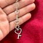 Close-up of Dior phone charm pendant with silver beads and clasp detail, highlighting one-of-a-kind design placed on hand 