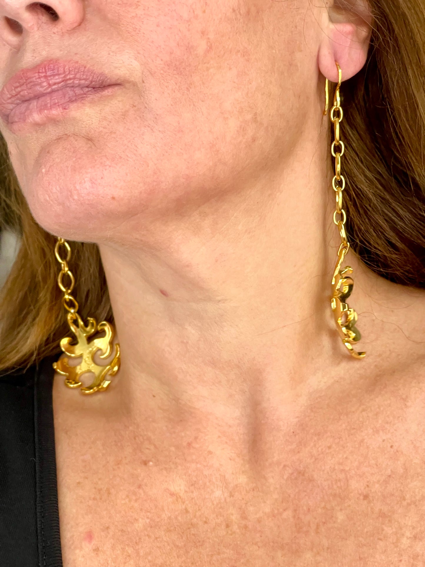 Side view of long Yves Saint Laurent drop earrings showing length and chain Worn by model