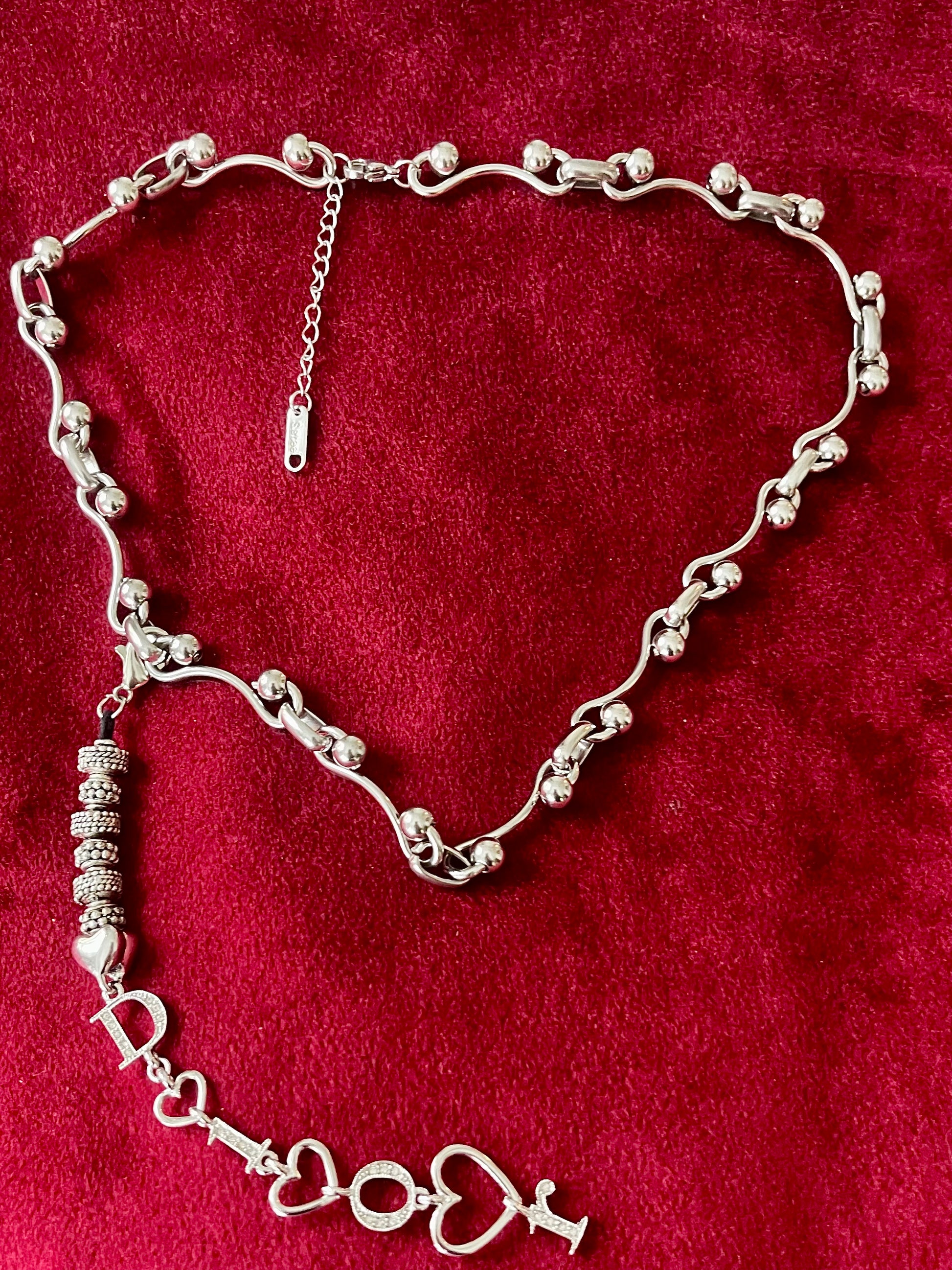 Authentic Dior phone charm upcycled into a silver-tone convertible pendant necklace, shown on red background