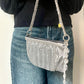 Side view of the One of a kind handmade Paco Rabanne repurposed silver pixel mesh bag held by model 