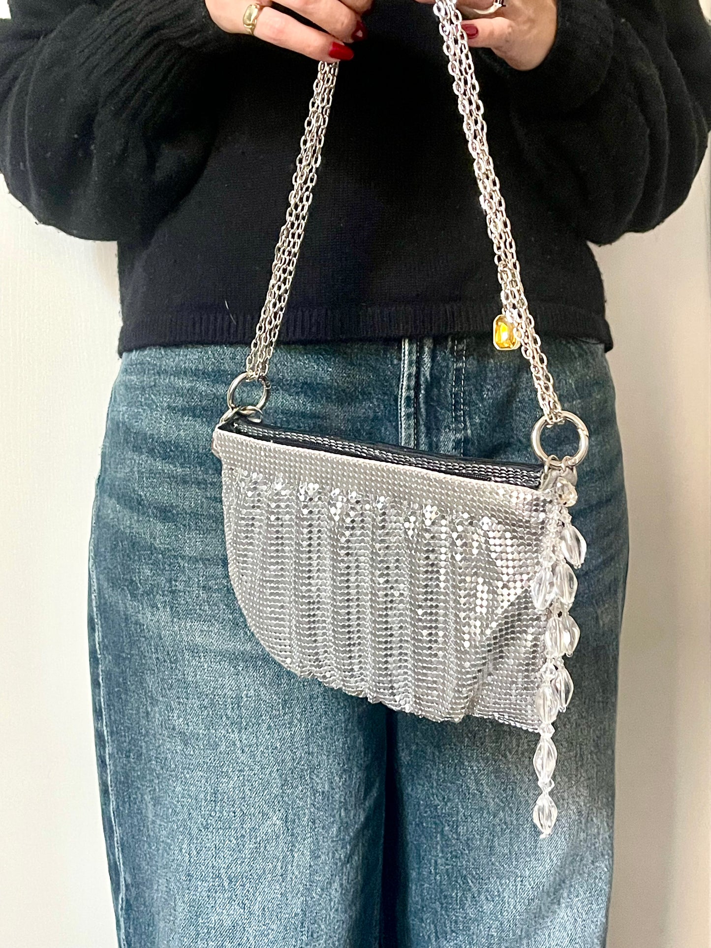 Side view of the One of a kind handmade Paco Rabanne repurposed silver pixel mesh bag held by model 