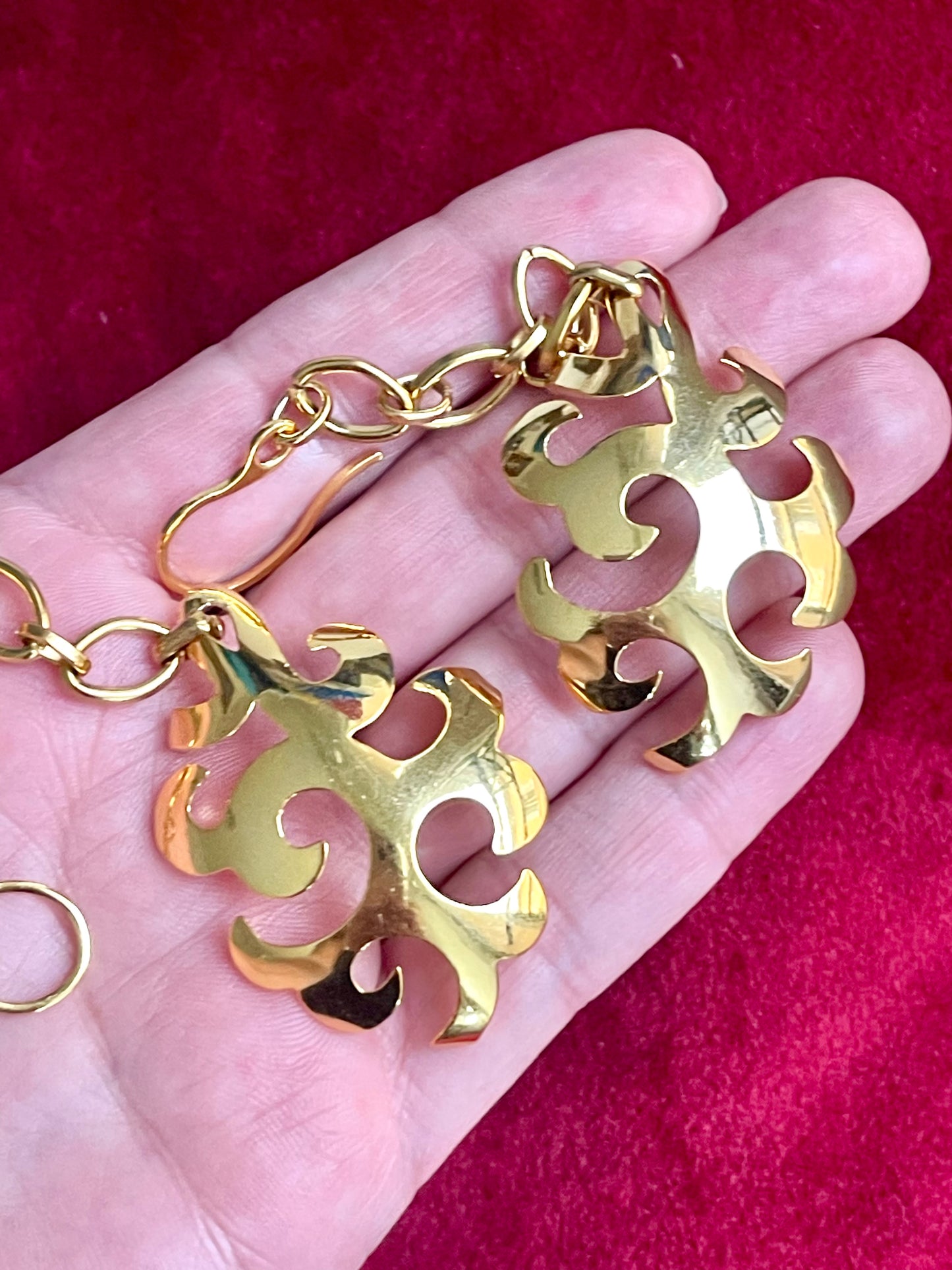 YSL vintage earrings displayed on palm highlighting gold plated shine