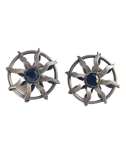 Vintage Paco Rabanne sun-design earrings in silver tone with black faceted stones, shown against a white background.