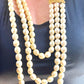 Vintage Yves Saint Laurent faux pearl statement necklace worn on model, showcasing multi-strand design and bold gold clasp at the neckline.