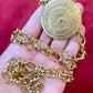 Yves Saint Laurent vintage scarf holder Gold chain necklace placed on hand 