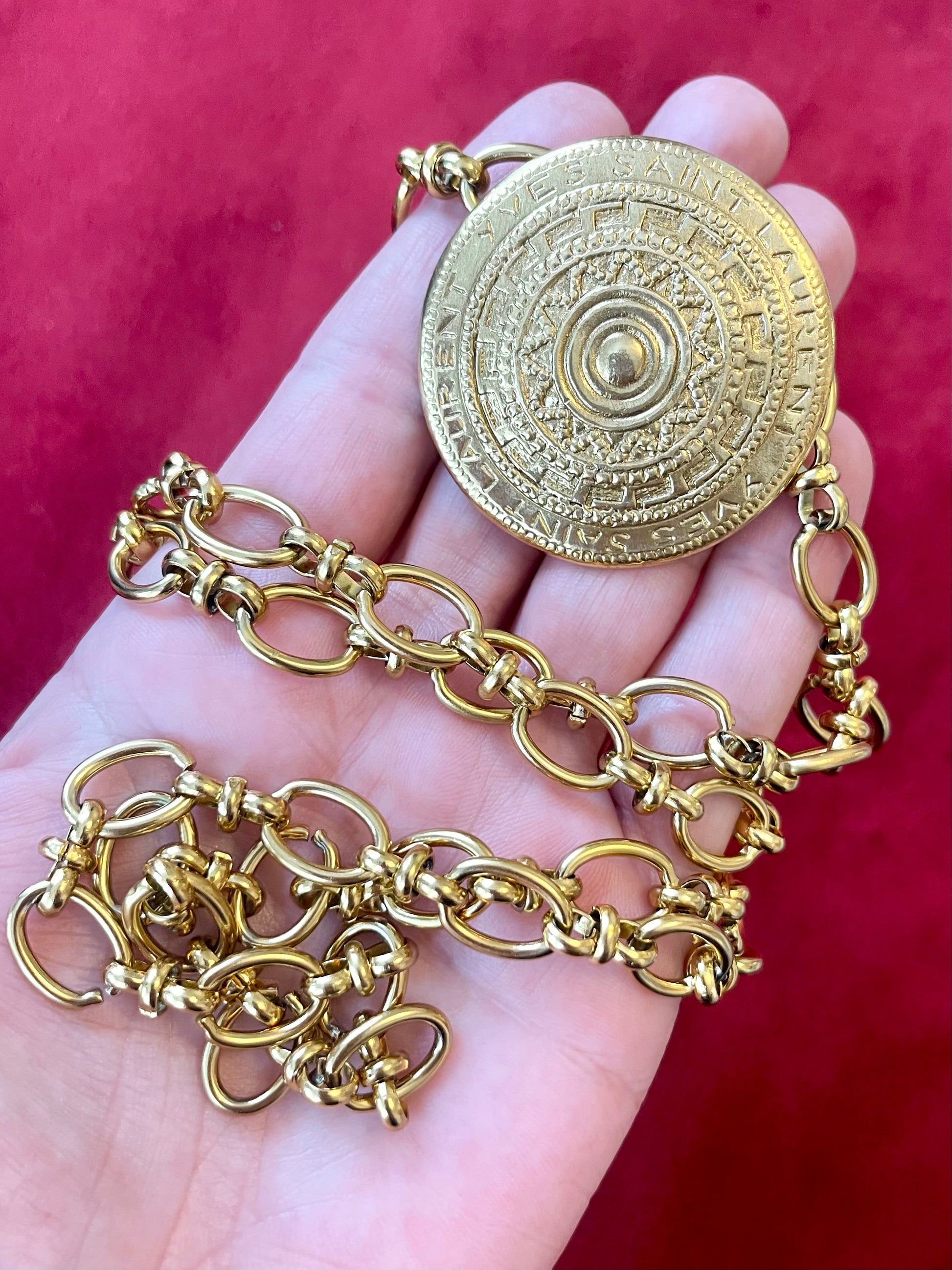 Yves Saint Laurent vintage scarf holder Gold chain necklace placed on hand 
