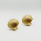 Gold-tone vintage Yves Saint Laurent Clam shell-shaped earrings displayed on white background showing detailed ribbed texture 