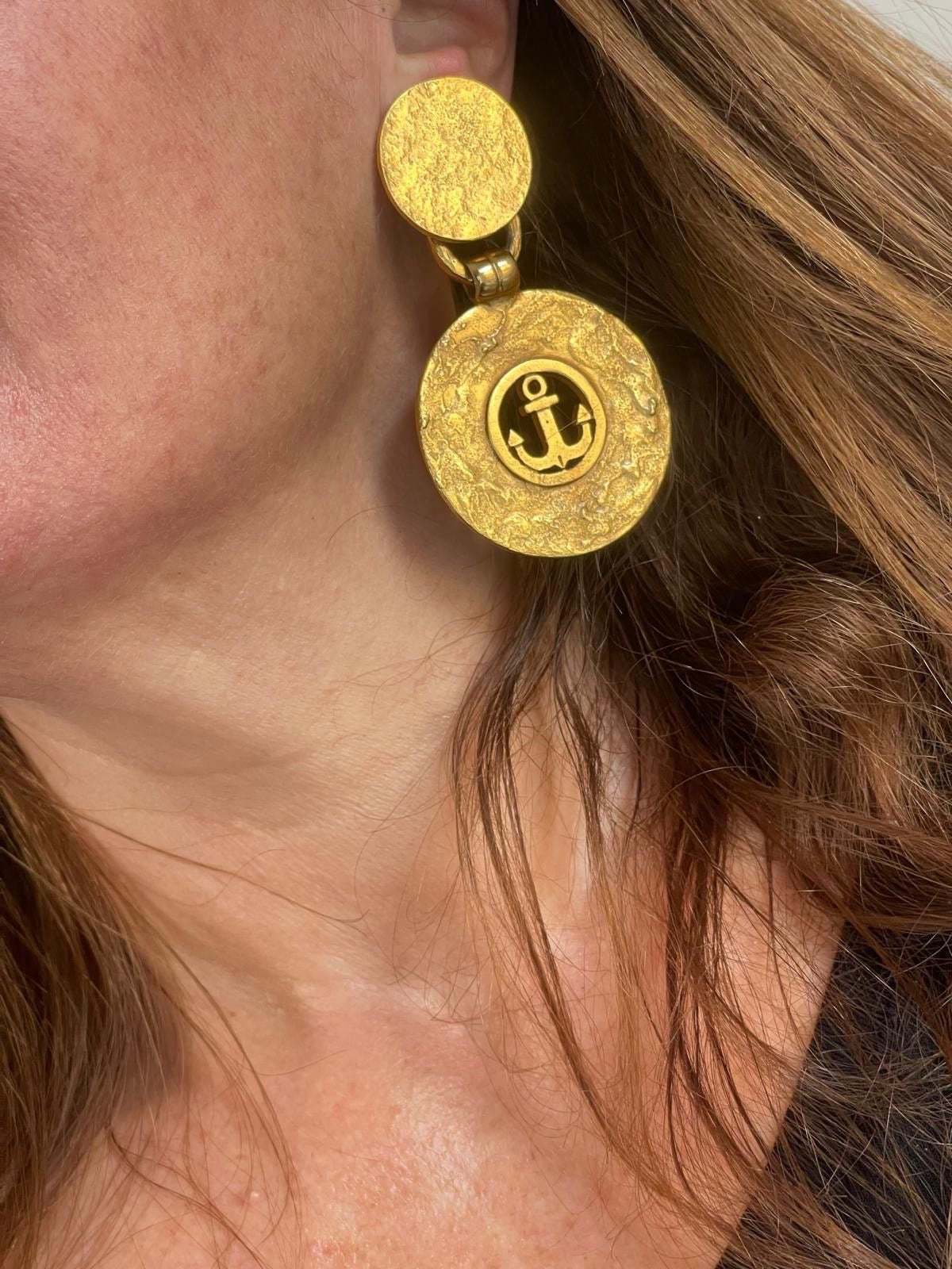 Side view of vintage YSL anchor statement earrings showing textured finish and clip-on backs worn by model