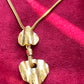 Refurbished 18KG vintage necklace with Arty heart-shaped pendants  from Yves Saint Laurent on a red fabric background