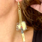 Yves Saint Laurent Earring worn by model showing asymmetrical design and charm arrangemen 