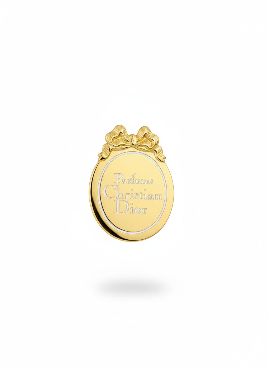 Gold Christian Dior pin on a white background