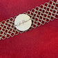 Signed Paco Rabanne mesh bracelet medallion detail On red background 