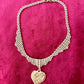 Vintage Refurbished 18KG Yves Saint Laurent 80s pendant Monet gold necklace displayed on a red velvet background 