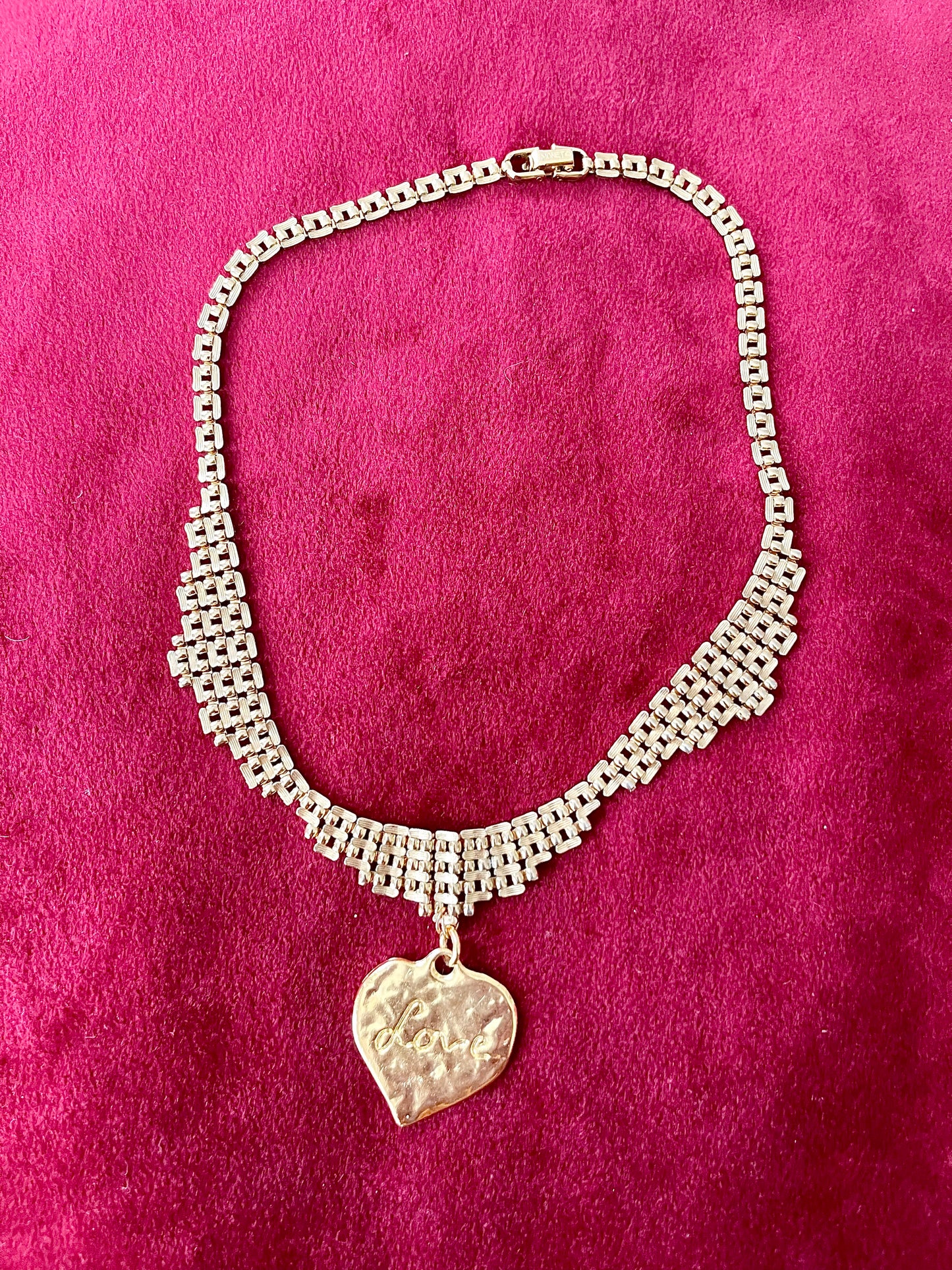 Vintage Refurbished 18KG Yves Saint Laurent 80s pendant Monet gold necklace displayed on a red velvet background 