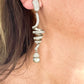 Close up look Grossé earrings worn, showcasing elegant drop design and pearl detail