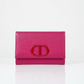 Pink wallet mirror from Dior with a CD logo on a white background