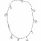 Silver Dior necklace with various charms on a white background