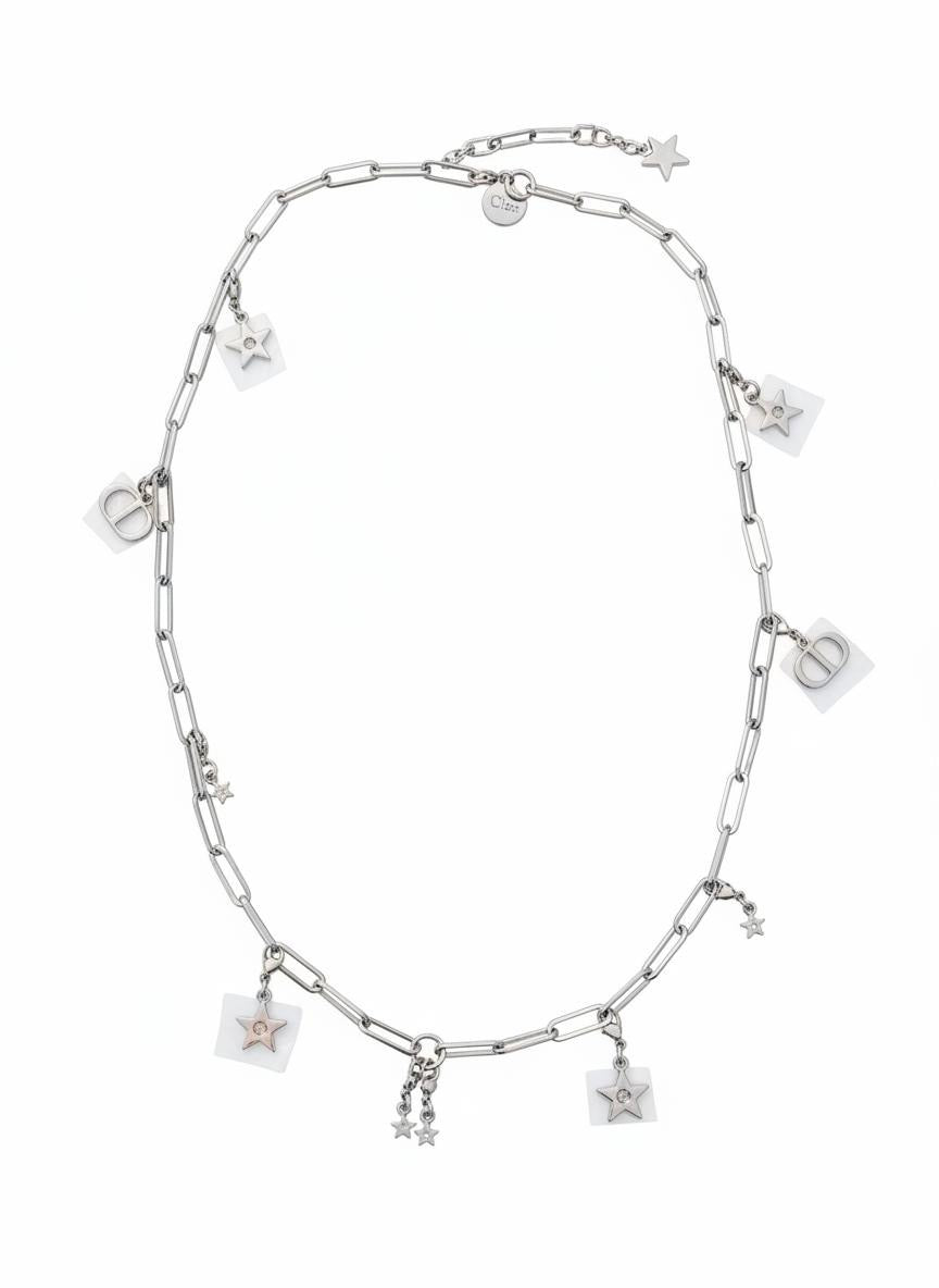 Silver Dior necklace with various charms on a white background