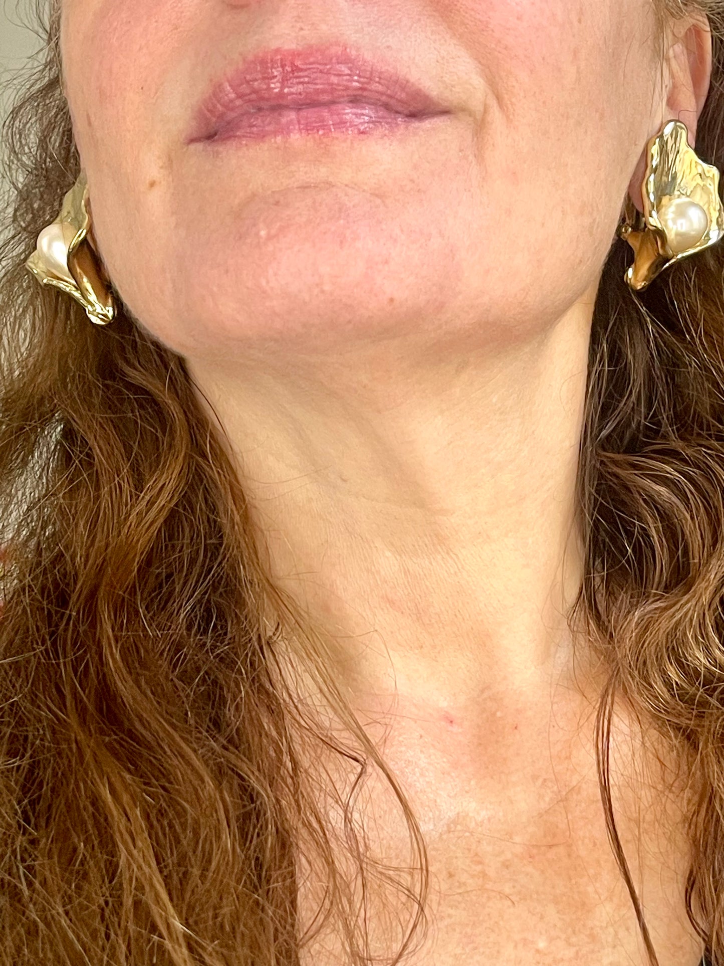 Close up in a woman wearing Authentic vintage Yves Saint Laurent earrings, organic gold-tone flower design with pearl accents
