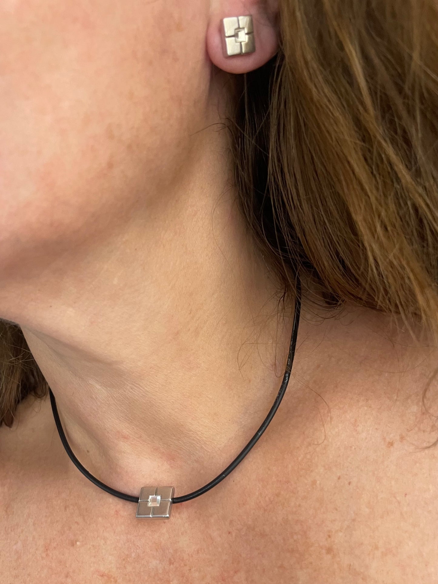 Worn by model YSL vintage silver earrings and matching pendant necklace set placed together 