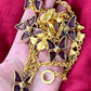 Vintage 80s five Yves Saint Laurent Butterfly Enameled pendants mounted on a Nina Ricci gold necklace, displayed on hand close up view 