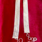 Flat lay of vintage silver Paco Rabanne mesh belt with hoops on red velvet background.