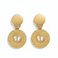 Vintage 1980s Yves Saint Laurent gold-tone anchor earrings with textured circular drop, clip-on design on white background 