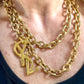 Worn by model Upcycled vintage Yves Saint Laurent gold-plated logo pendant on long stainless steel chain necklace showing different styles 