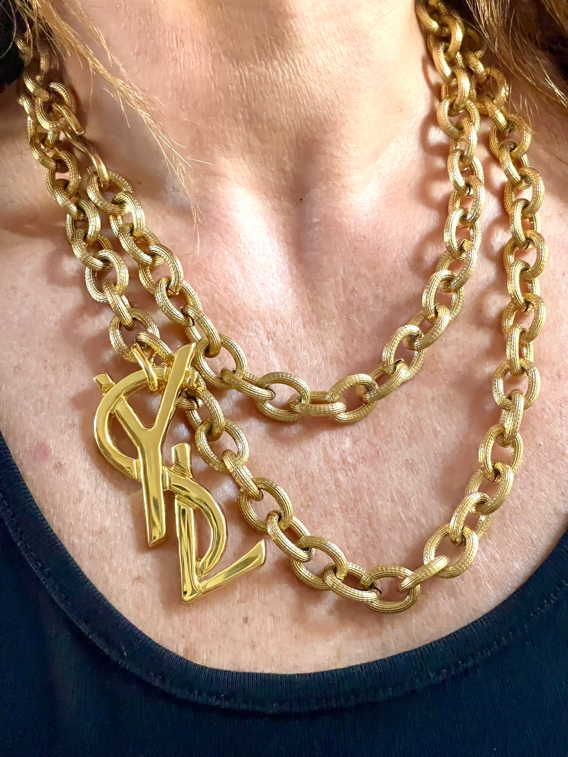 Worn by model Upcycled vintage Yves Saint Laurent gold-plated logo pendant on long stainless steel chain necklace showing different styles 