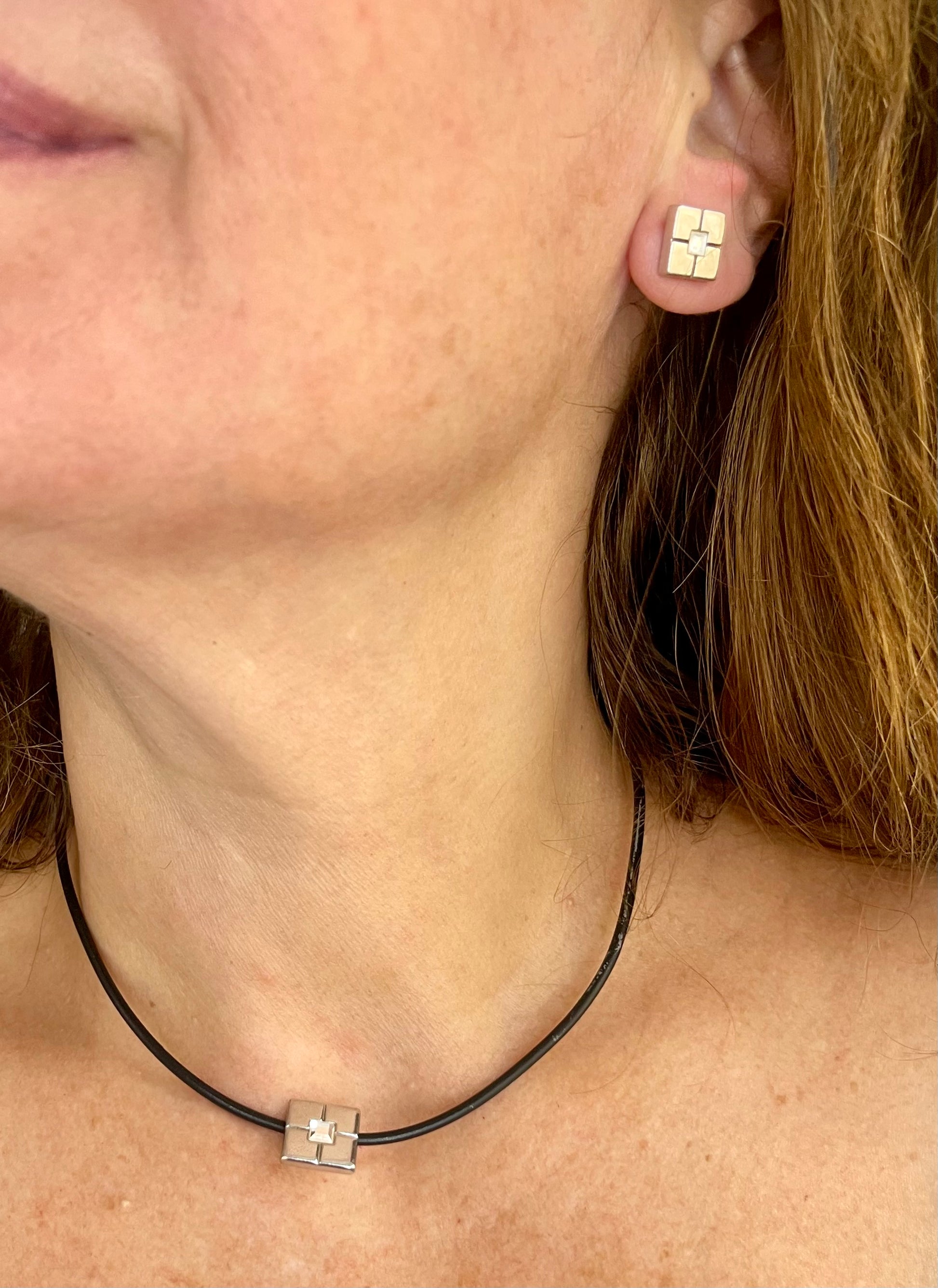 YSL vintage silver earrings and matching pendant necklace set placed together worn by model 