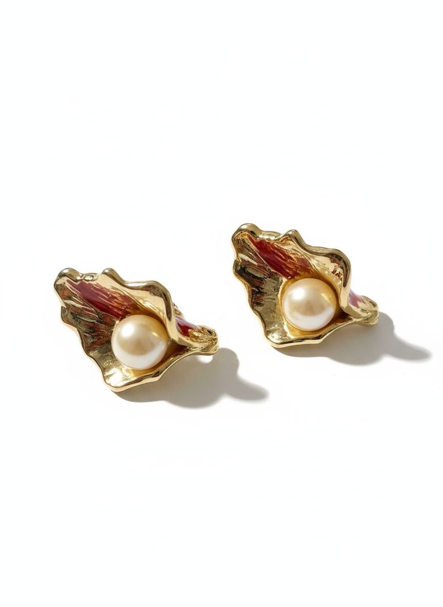Vintage Yves Saint Laurent gold-tone calla lily earrings with pearl centers, sculptural floral design On a white background 