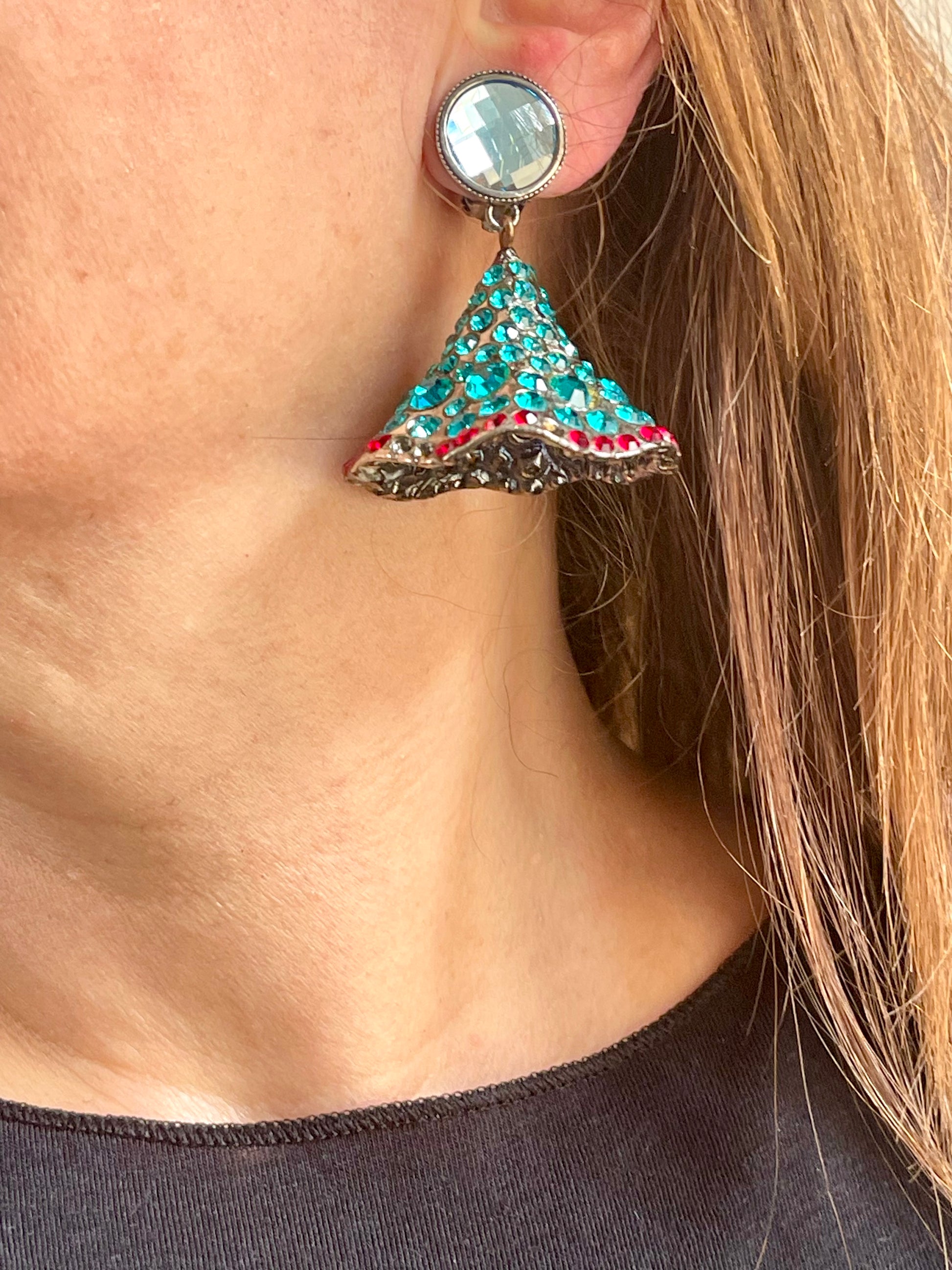 Close-up of Yves Saint Laurent Rive Gauche vintage statement earrings with turquoise and red rhinestones worn by model showing the imperfections left side 