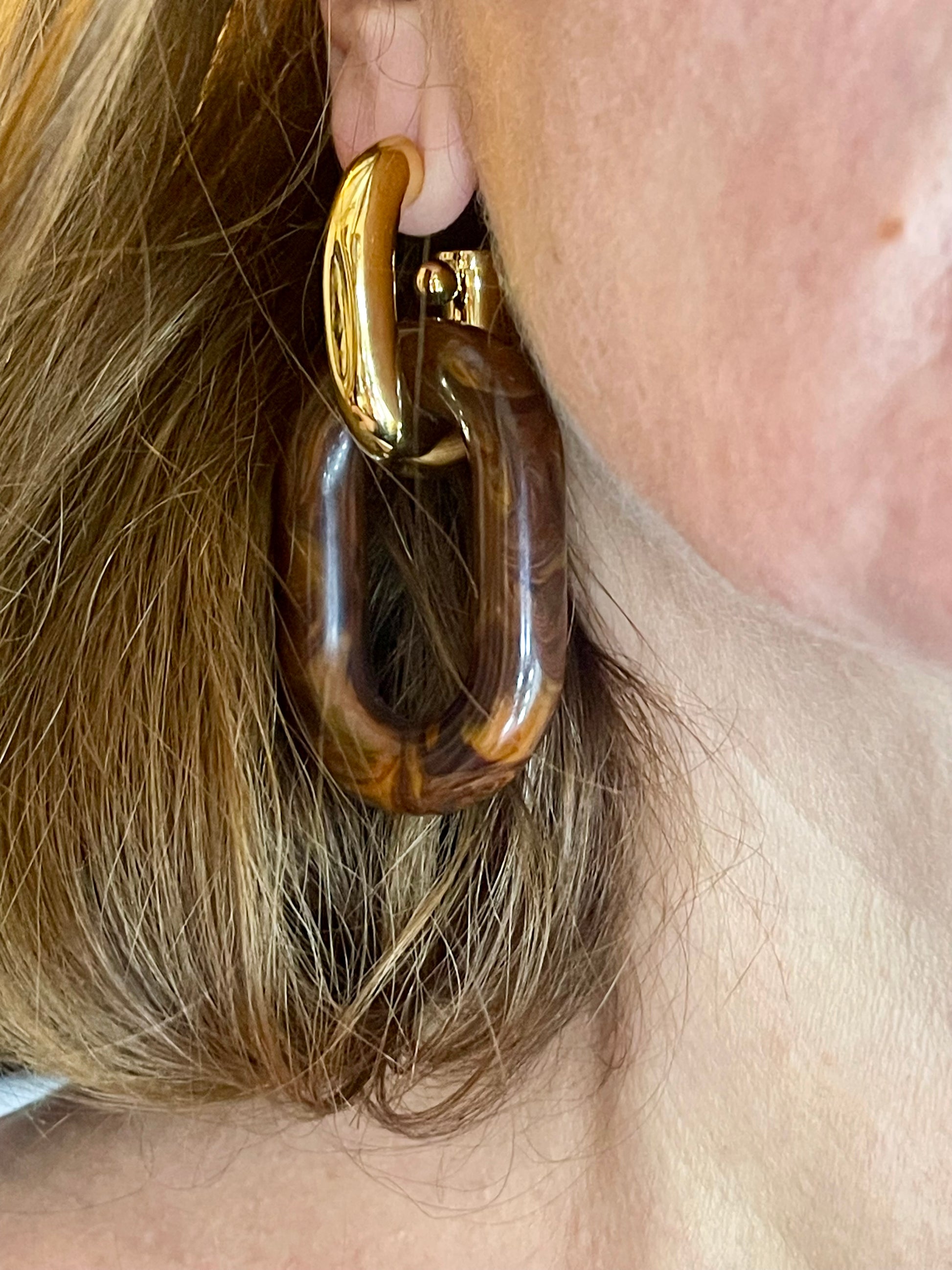 Gold hoop XL Link Paco Rabanne earring with wooden finish worn by a person