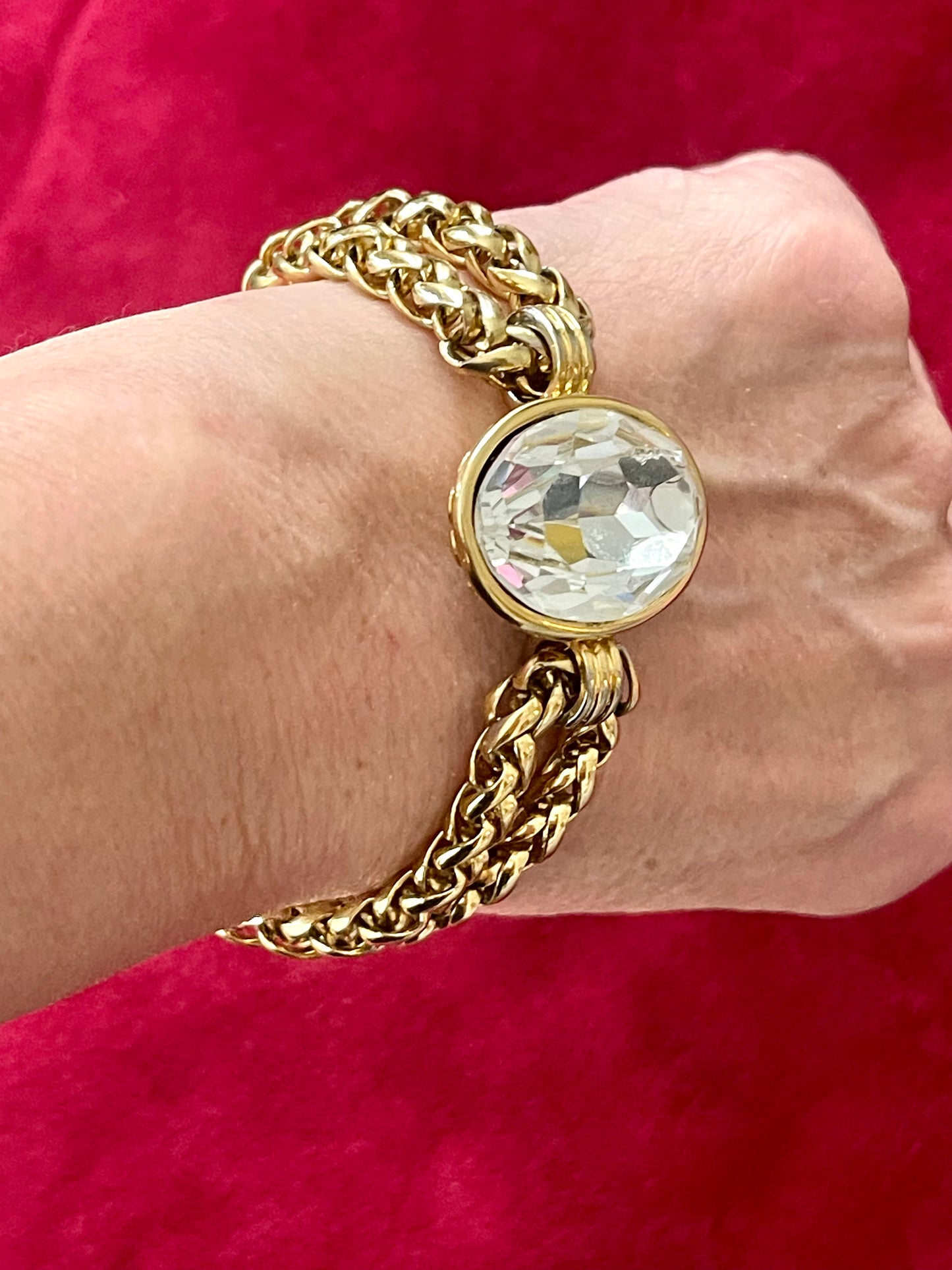 Authentic vintage Yves Saint Laurent bracelet large sizeWorn in wrist with a red background 