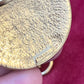 Gold vintage Yves Saint Laurent with engraved made in France held by a hand against a red background