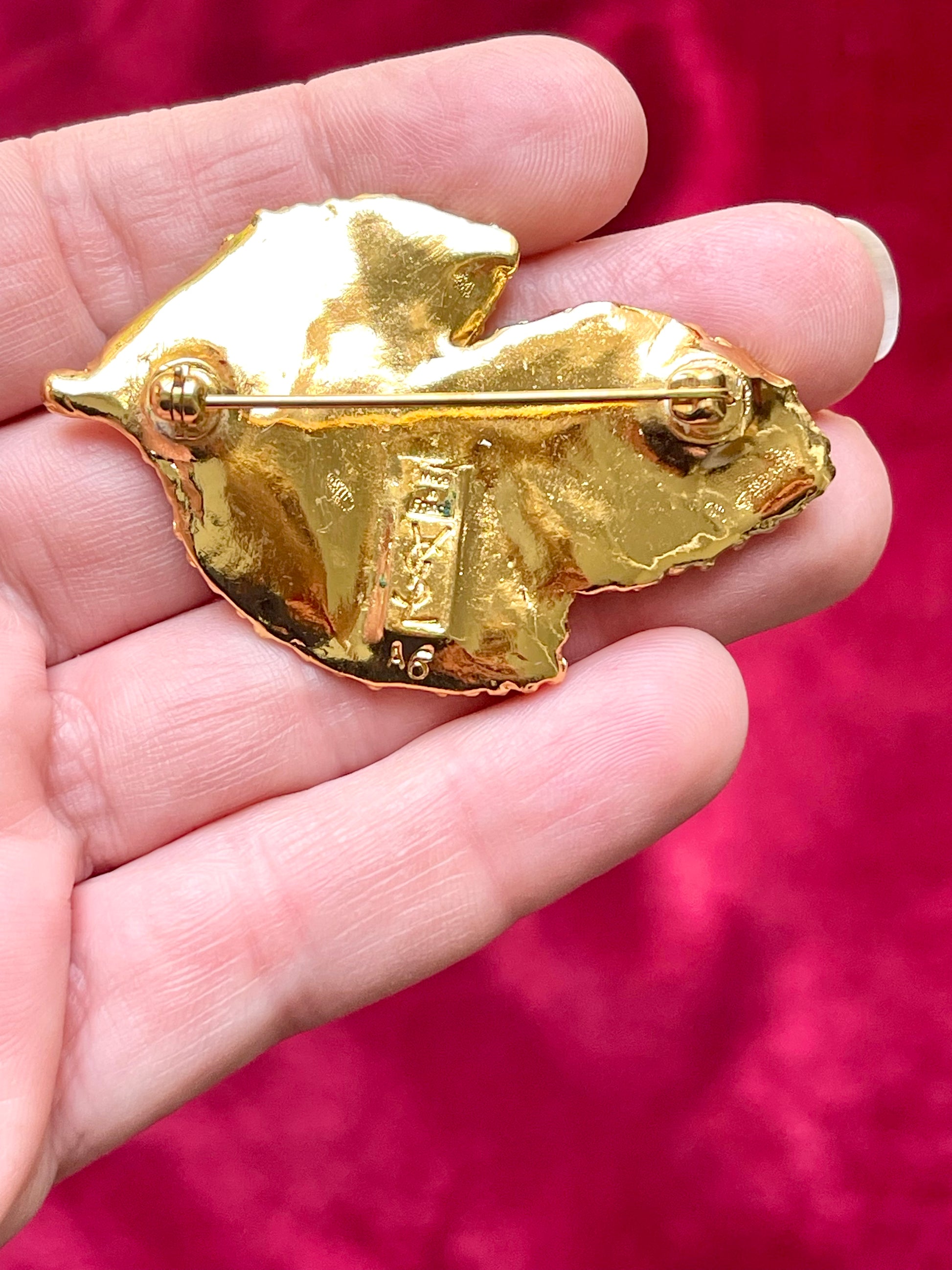 Back view signed YSL made in France Vintage Yves Saint Laurent 80s 90s gold tone leaf brooch excellent condition on white and red background 